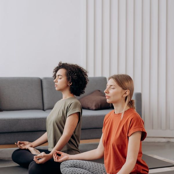 Woman practicing a gentle mobility exercise in a bright room.